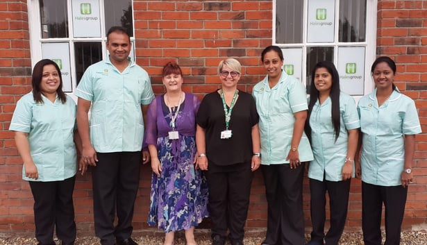 a group of care workers standing in front of a brick building