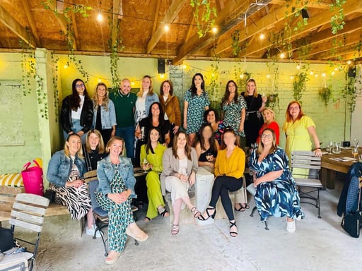 a group of people posing for a photo in front of a green wall